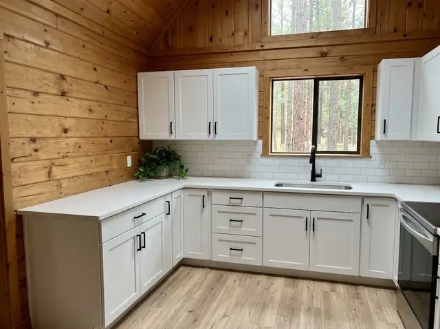 Cabin kitchen with white shaker cabinets, subway tile backsplash and pine walls